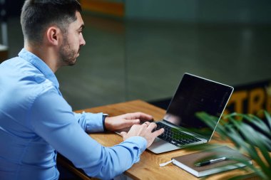 Şirketin başkanı ofisteki masada dizüstü bilgisayarla çalışıyor. Yakınlarda bir defter ve kapı kolu var. Yönetim ve planlama. çevrimiçi eğitim.