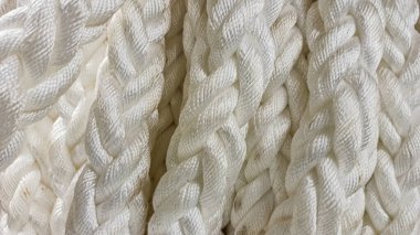 Bir kayığın demirli kahverengi halatı, bir kordon üzerinde sarılmış, ucu düzgünce yana kıvrılmış. Bir yaz günü, gölün üzerindeki tahta iskele..