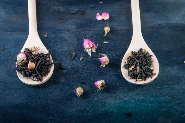 Tea leaves with rose buds in wooden  background. — Stock Photo, Image