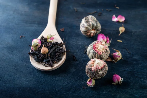 Tea leaves with rose buds in wooden  background. — Stock Photo, Image