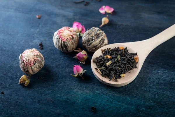 Tea leaves with rose buds in wooden  background. — Stock Photo, Image