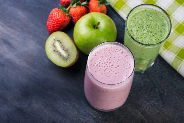 Gesunde Smoothies in Gläsern mit Zutaten auf dunklem Hintergrund — Stockfoto