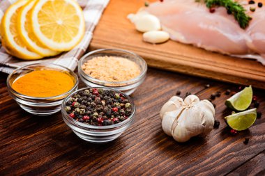 Ahşap arka planda baharatlı çiğ tavuk göğsü.