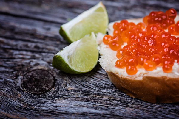 Pan con mantequilla y caviar rojo con lima —  Fotos de Stock