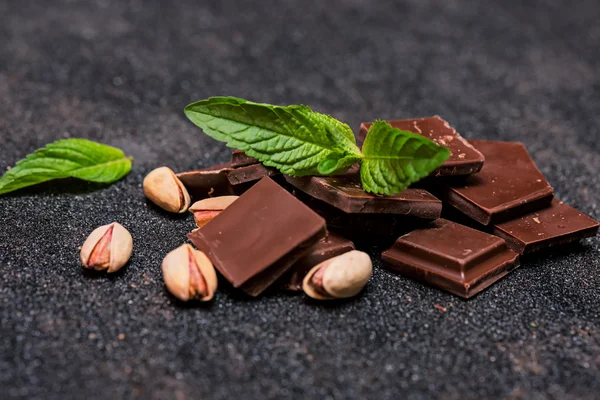 Stukken van chocolade met munt en noten — Stockfoto