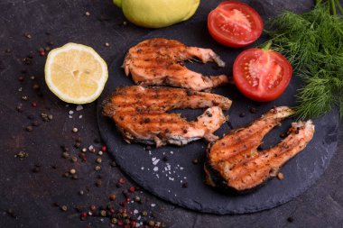 Koyu masada ızgara taze somon bifteği, biber ve limon. Sağlıklı yiyecek için balık