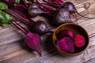 Tahta kırsal masada yeşil yapraklı taze pancarlar. Pancar kökü hasadı