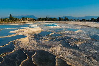 Türkiye 'nin Pamukkale kentinde gün batımında doğal travertin havuz ve terasları