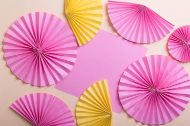 Sarı arkaplanda renkli yuvarlak kağıt vantilatörler 