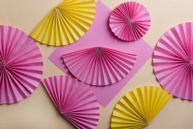 Sarı arkaplanda renkli yuvarlak kağıt vantilatörler 