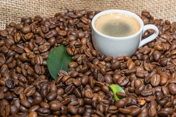 Tazza di caffè con fagioli tostati in iuta . — Foto Stock