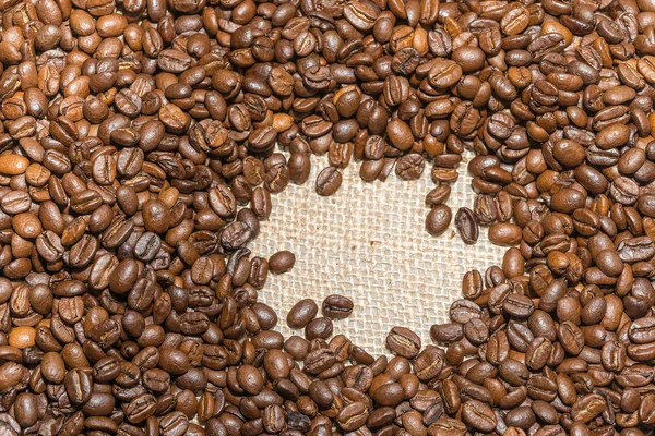 Sfondo torrefatto chicchi di caffè su texture iuta — Foto Stock