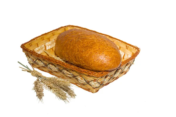 Loaf in a basket with ears of wheat — Stock Photo, Image