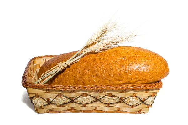 Loaf in a basket with ears of wheat — Stock Photo, Image