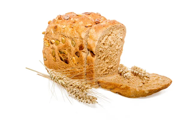 Sliced bread with nuts and ears of wheat — Stock Photo, Image