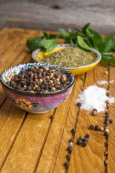 Gewürze und Kräuter in Schalen auf Holztisch. — Stockfoto