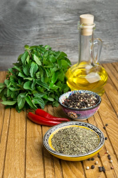 Spices, mint and oil  on old wooden table — Stock Photo, Image