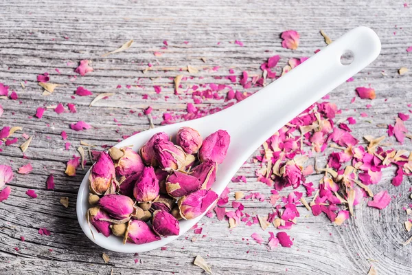 Dried rose buds in ceramic spoon — Stock Photo, Image