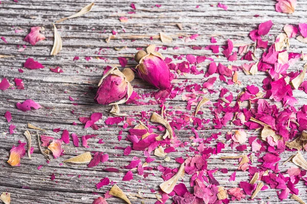 Achtergrond met rozenblaadjes en twee gedroogde bloemen — Stockfoto