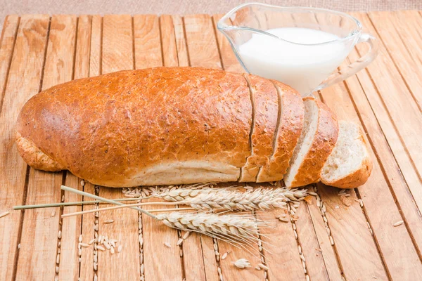 Fresh sliced loaf with grains and milk — Stock Photo, Image