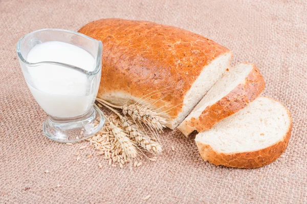 Fresh sliced loaf with grains and milk — Stock Photo, Image