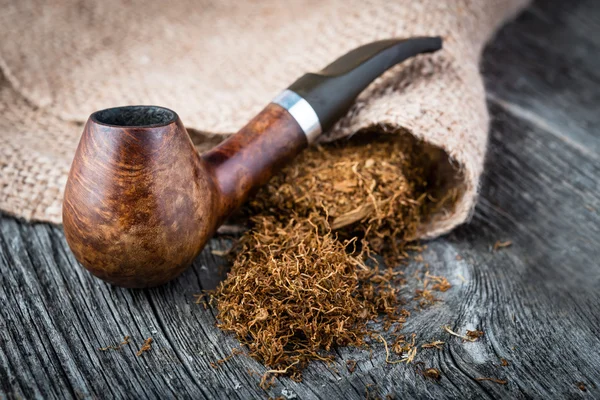 Smoking  briar pipe and tobacco on burlap — Stock Photo, Image
