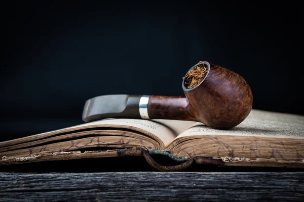 Smoking pipe on the opened old book — Stock Photo, Image