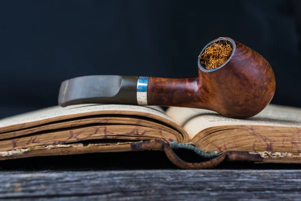 Smoking pipe on the opened old book — Stock Photo, Image