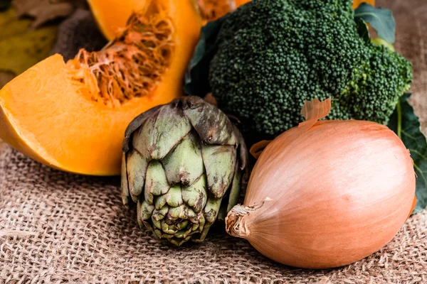 Alcachofa, calabaza en rodajas, cebolla y broccolli en arpillera —  Fotos de Stock