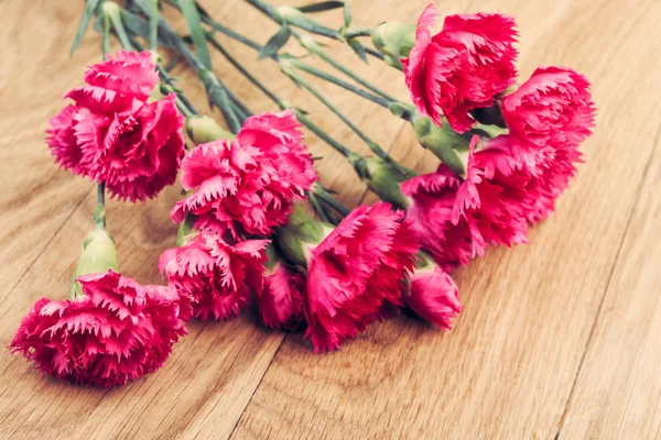 Свежие розовые гвоздики на деревянном фоне — стоковое фото
