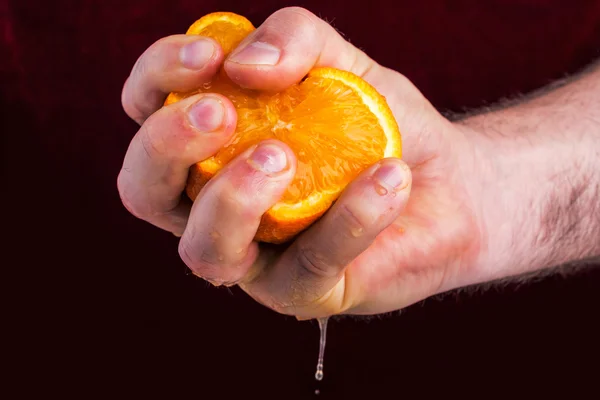 Mano masculina apretando naranja sobre fondo de morera . —  Fotos de Stock