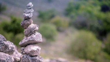 Yeşil arkaplanda Dengelenmiş Zen taşları.