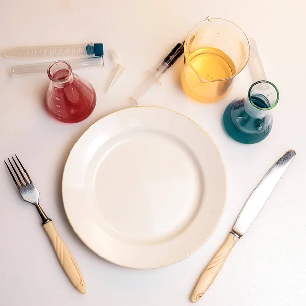Un piatto con cucchiaio e forchetta in laboratorio. Dieta concetto con sostanze chimiche. — Foto Stock