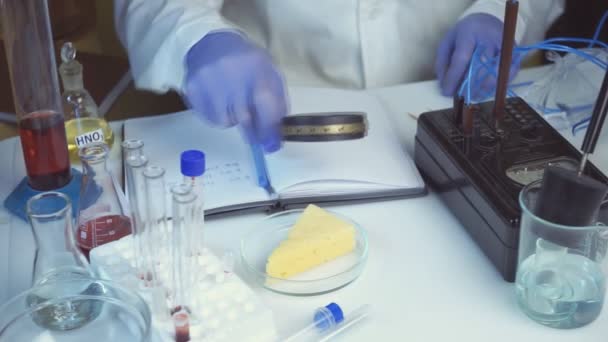 Food safety laboratory, scientist concept. Inspector writing test note on notebook after doing research in lab. Close up. — Stock Video