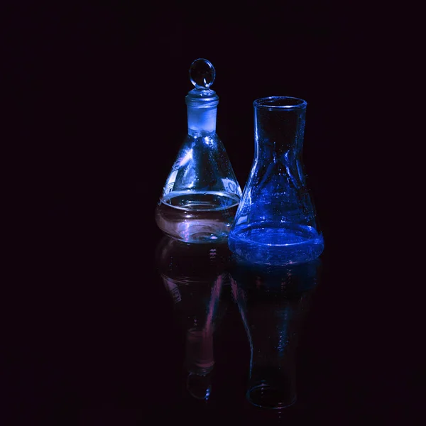 Different laboratory glassware with water and empty with reflection isolated on black — Stock Photo, Image