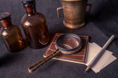 Fotoğraf: Siyah zemin üzerinde Vintage cam şişeler ve büyüteç.