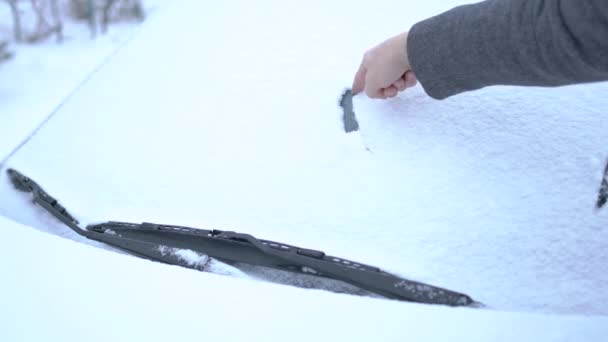 Na prodej napsaný ve sněhu na sněhu auta zakrytém čelním sklem — Stock video
