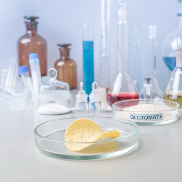 Stäng potatischips i labbet. Laboratorieförfarande för livsmedelssäkerhet, analys av potatischips från marknaden. Arbetsplatslabbassistent. — Stockfoto