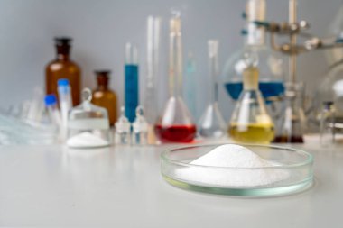 Laboratuvarda fotoğraf sporu takviyesi var. Laboratuvar arka planında kreatin tozu ve amino BCCA