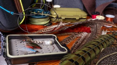 Ahşap bir masaya yem bağlamak için malzemeler ve aletler. Uçan Balık Durgun Hayat.