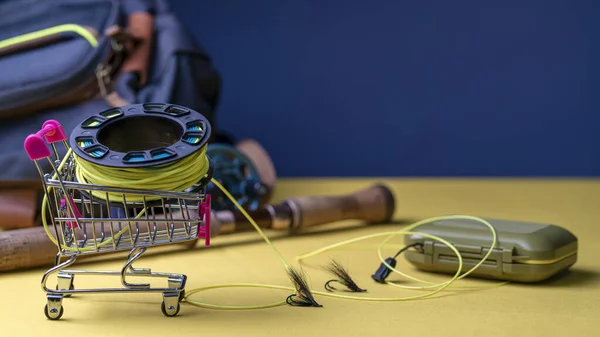 Fishing rod, fly box, fly fishing reel with line in mini cart. Fly fishing shopping concept. — Stock Photo, Image