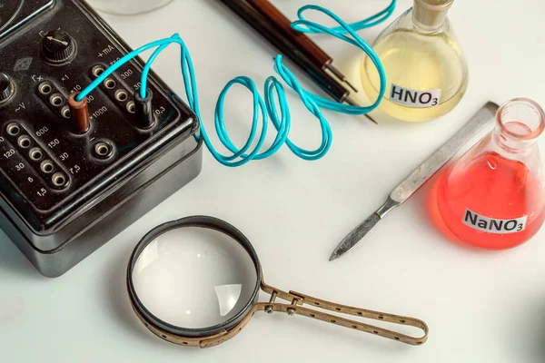 Frasco de laboratório de vidro, lupa e instrumentos de medição sofisticados. O conceito de análises médicas e químicas. — Fotografia de Stock