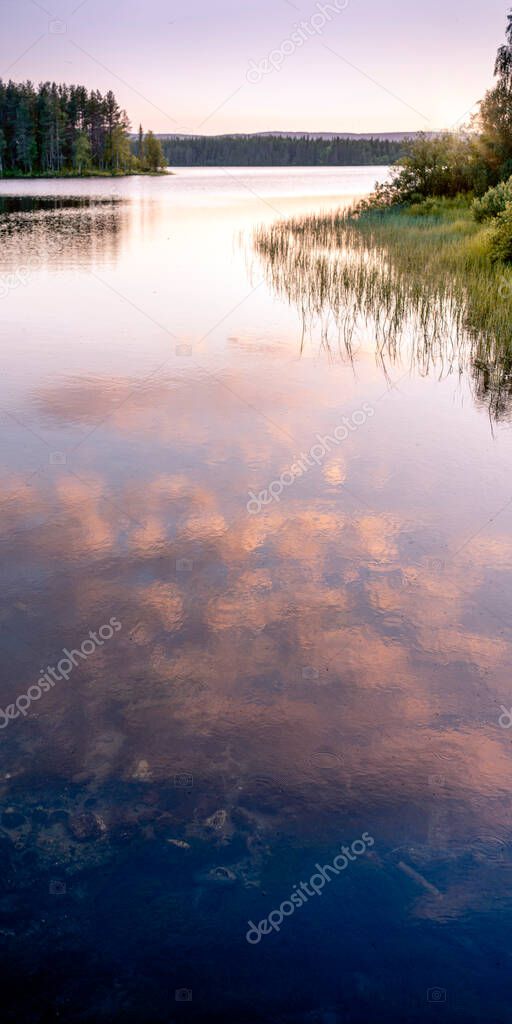 Sunset on the lake in summer. Wild nature of the taiga. Romantic mood, travel.