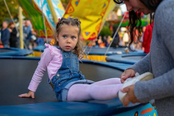 Annem kızlarına trambolinde çocuk matinesinde sandalet giydirir..