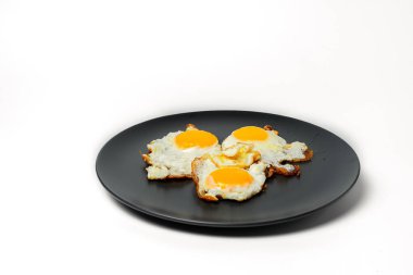 Beyaz arka planda gri tabakta 3 yumurtadan omlet.