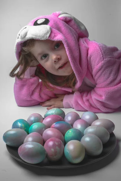 Девочка в костюме кролика с пасхальными яйцами — стоковое фото