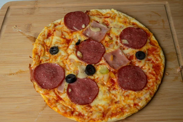 Tahtada peynirli ve sosisli sulu pizza.