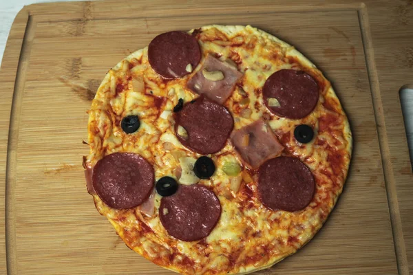 Tahtada peynirli ve sosisli sulu pizza.