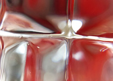 Kırmızı bir nesneden yansıyan kaldırma, kesiklerin arasından bir desen oluşturur.