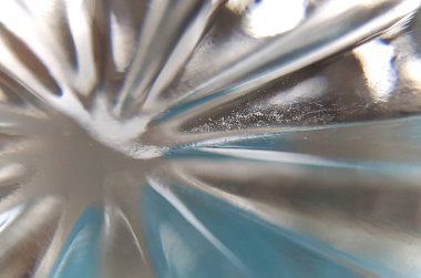 Mavi yansıyan ışık desenleri sıradan bir camın altından görülüyor.